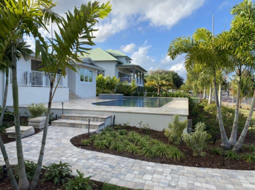 Custom in ground pool with patio and background design from CoastLife Pools South Florida