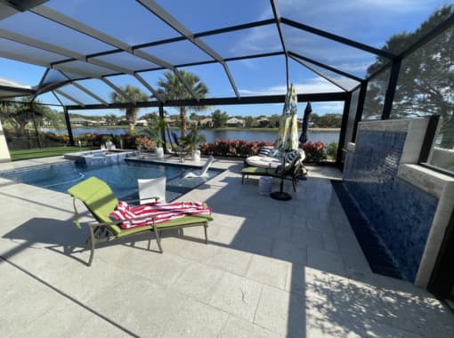 Custom in ground pool with stone tile patio inside a lanai from CoastLife Pools South Florida