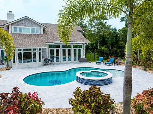 Custom in ground pool and spa with stone patio from CoastLife Pools in South Florida